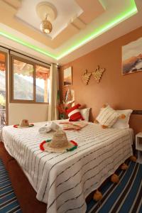 Un dormitorio con una cama grande con sombreros. en Dar Tamatert, en Tamatert