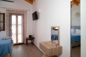 a bedroom with a bed and a table and a mirror at Oceanis apartment in Symi