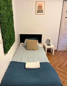 Un dormitorio con una cama azul con una planta en la pared en SPIN City by Katowice # One & Z E R O, en Katowice