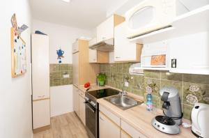 a small kitchen with white cabinets and a sink at Ferienwohnung Nolte Grömitz in Grömitz