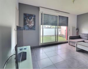 a living room with a couch and a glass table at Appartement Cosy in Le Crès