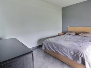 a bedroom with a bed and a black table at Appartement Cosy in Le Crès