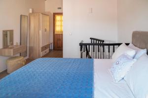 a bedroom with a bed with a blue comforter at Oceanis apartment in Symi
