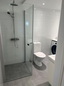 a bathroom with a toilet and a glass shower stall at Nyare lägenhet på Smögen, nära allt in Smögen