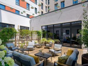 un patio con sofás y mesas en un edificio en Novotel Münster City, en Münster