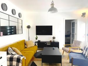 een woonkamer met een gele bank en een tv bij Petite Mansion in Nasicz +13 foto's