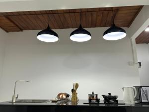 una cucina con tre luci sopra un bancone di Apartment B W Kitchen 5 Mins Beach 20 Mins Airport a Negombo