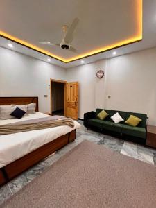 a bedroom with a large bed and a couch at Sarai Abbottabad in Abbottabad