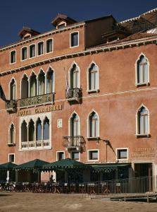 a large brick building with tables and chairs in front of it at Hotel Gabrielli Venezia - Starhotels Collezione in Venice