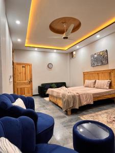 a bedroom with a bed and chairs and a ceiling at Sarai Abbottabad in Abbottābād