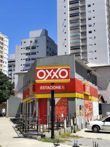 AVSO-Filiale in einer Stadt mit hohen Gebäuden in der Unterkunft 25C - Pé na Areia do Tombo, 1 Suite Master, Ar Cond, 2Wc, 1 vaga, Roupa de Cama e Vivo fibra in Guarujá