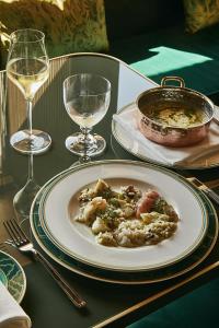 a table with a plate of food and glasses of wine at Hotel Gabrielli Venezia - Starhotels Collezione in Venice