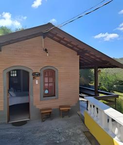 a small building with a roof with a porch at Chalés São Francisco I in Santo Antônio do Pinhal