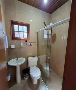 a bathroom with a toilet and a sink and a shower at Chalés São Francisco I in Santo Antônio do Pinhal