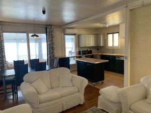 Una sala de estar con dos sofás y una cocina. en Chez Hughes, en Montaigut-sur-Save