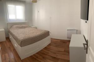 Un dormitorio con una cama y suelo de madera. en Chez Hughes, en Montaigut-sur-Save