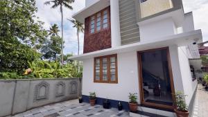 a house with a courtyard in front of it at Gypsy Walker Plus in Varkala