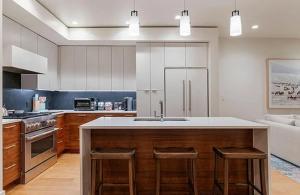 ジャクソンにあるSlopeside 2BR Retreat at Snow King Walk to Townのキッチン(シンク、カウンター、スツール付)