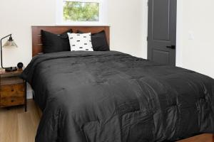 a bedroom with a bed with a black comforter at Free parking, Free WiFi 2 bed home in Tampa
