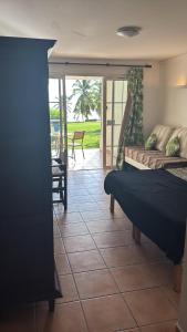 a bedroom with a bed and a patio with a table at Appartement avec vue mer en Guadeloupe in Sainte-Anne