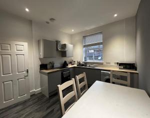 a kitchen with a table and chairs and a white door at Perth City Centre Apartment - Short & Long Stays Welcome - 2x Smart TVs - Sky TV - Fast WiFi - Fully Equipped - Located Next to All Amenities in Perth