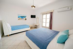 a bedroom with a bed and a chair and a window at my life suites in Fira +67 photos
