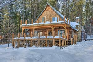 a log cabin in the woods in the snow at Alpine Adventures Cozy Log Cabin with Deck and Views! in Alpine