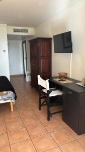 a living room with a desk and a tv at Appartement avec vue mer en Guadeloupe in Sainte-Anne