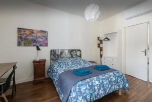 een slaapkamer met een bed met blauwe lakens en een bureau bij Apart city in Montargis