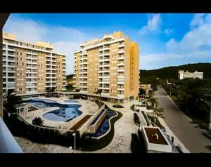 a view of a resort with a pool and buildings at Vista Serra e Mar in Bertioga