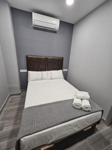 a bedroom with a bed with two towels on it at Tanez Garden Apartamentos in Madrid