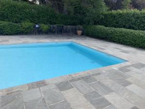 a large blue swimming pool in a yard at Appartement Cosy in Le Crès