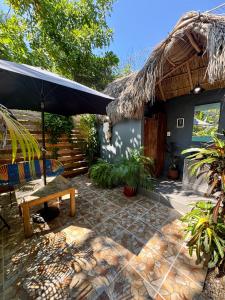 a patio with an umbrella and a bench and stairs at Palapa Chili # in Sayulita