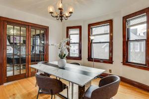 a dining room with a table and chairs and windows at 1 Mi to Downtown Dubuque! Spacious Home in Dubuque