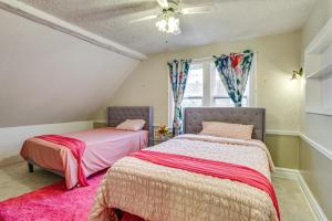 two beds in a room with a pink carpet at 1 Mi to Downtown Dubuque! Spacious Home in Dubuque