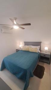 a bedroom with a blue bed with a ceiling fan at Departamento Mike's in Nuevo Vallarta 