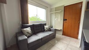 a living room with a couch and a window at Flat funcional e moderno em Uvaranas-com elevador in Ponta Grossa