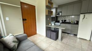 a kitchen with a table and a couch in a room at Flat funcional e moderno em Uvaranas-com elevador in Ponta Grossa
