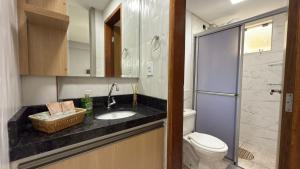 a small bathroom with a sink and a toilet at Flat funcional e moderno em Uvaranas-com elevador in Ponta Grossa +11 photos