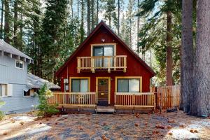a red house with a deck in the woods at Tahoe West Shore Escape in Tahoe City