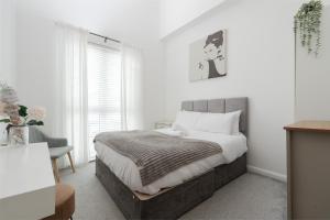 a bedroom with a large bed and a chair at City Stay Haven - Coop Live - Etihad - Sleeps 9 - Free Parking in Manchester