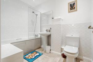a white bathroom with a toilet and a sink at City Stay Haven - Coop Live - Etihad - Sleeps 9 - Free Parking in Manchester +25 photos