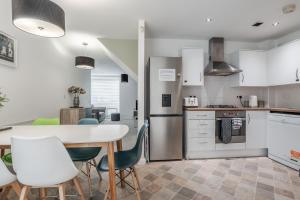 a kitchen with a table and chairs in a kitchen at City Stay Haven - Coop Live - Etihad - Sleeps 9 - Free Parking in Manchester