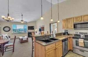 een keuken met houten kasten en een woonkamer bij Penthouse Retreat Steps from the Gondola in Park West Ski Area Heliport