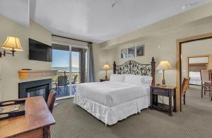 een grote slaapkamer met een bed en een open haard bij Penthouse Retreat Steps from the Gondola in Park West Ski Area Heliport