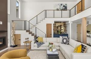 a living room with a white couch and a staircase at Ski-In Ski-Out Escape with Mountain Views in Snowm in Snowmass Village
