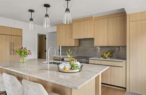 a kitchen with wooden cabinets and a island with a counter top at Ski-In Ski-Out Escape with Mountain Views in Snowm in Snowmass Village +7 photos