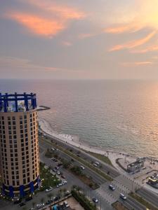 une vue sur l'océan et un grand immeuble dans l'établissement شقةباأطلالة بحرية برج الجوهره داماك Damac AlJawharah Tower, à Quai