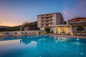 een groot zwembad voor een gebouw bij Apartments Top Hill in Trogir