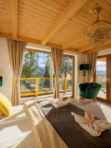 a bedroom with a large bed and a large window at Osada Gubałówka na Polanie Pająkówka View Jacuzzi & Sauna in Kościelisko